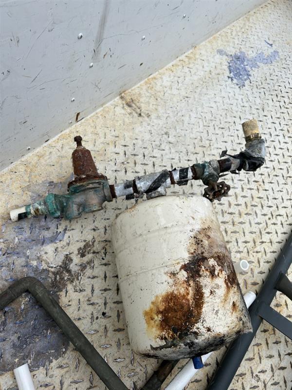 An old and rusted water heater pulled from a home