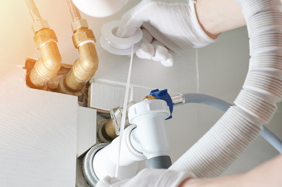 Plumber in white gloves adding Plumber's or PTFE tape onto a leaky port