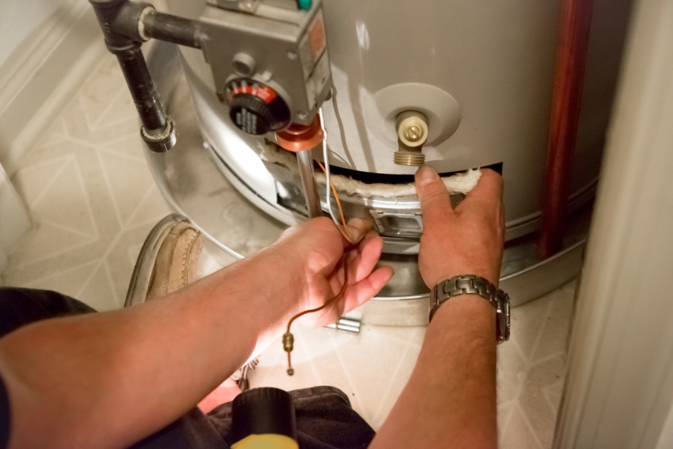 Plumber doing repairs on a water heater.