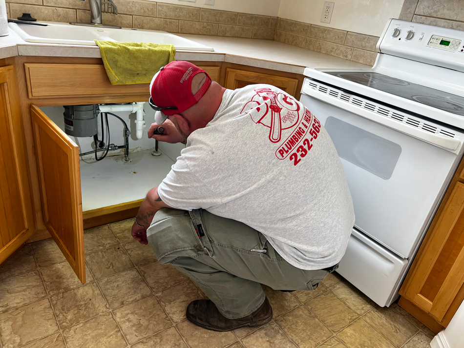 B&G plumber looking under a sink