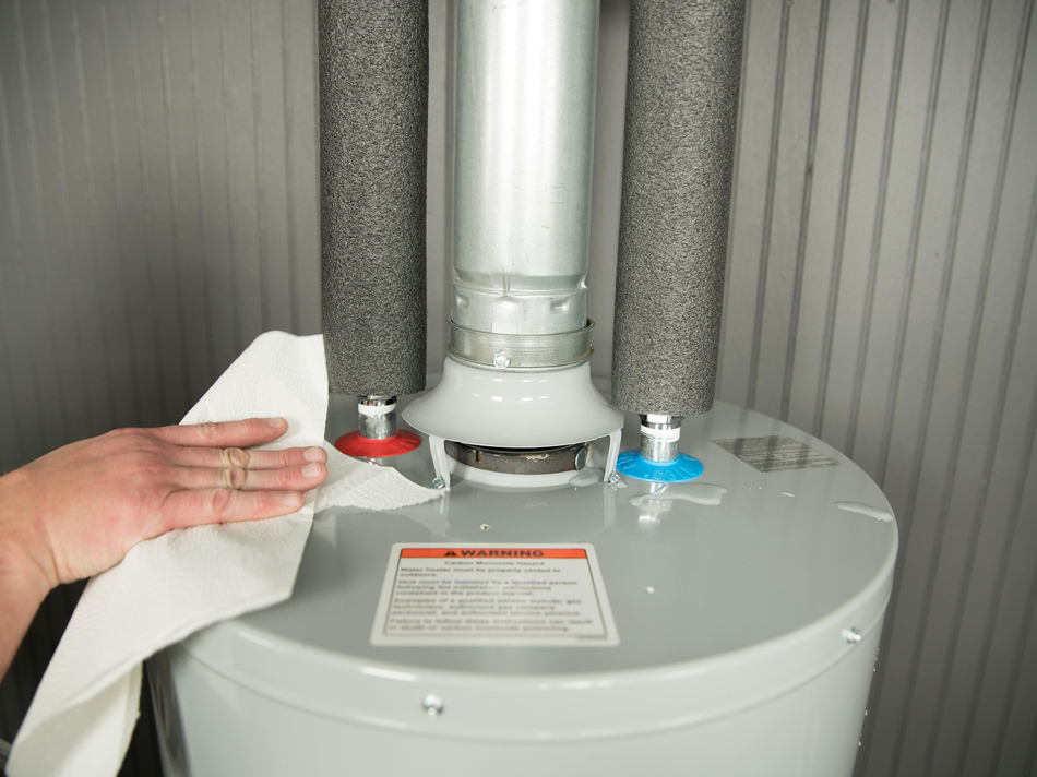 Person wiping water heater